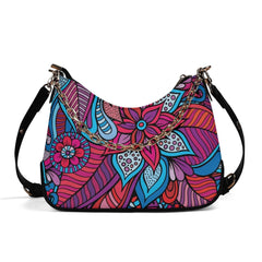 Vibrant floral bohemian chic shoulder bag with bold pink, blue, and purple patterns and gold chain and black adjustable strap