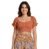Flame Pea Orange puff sleeve crop top with open tie back and ruched bust, styled with Binka print wide-leg pants — Blissfully Brand made-to-order fashion