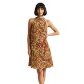 sleeveless dress with a vibrant psychedelic pattern in shades of yellow, orange, and brown. The dress has a halter neckline and an A-line silhouette. Blissfully Brand