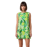 Woman wearing Misa print green paisley mini vest dress with round neckline and A-line silhouette, styled with white lace-up boots - Blissfully Brand