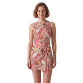 Woman wearing Nami print sleeveless bodysuit dress in pink and coral paisley pattern with built-in matching shorts