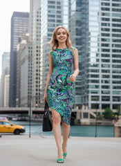 Bold retro-chic Nela dress by Blissfully Brand featuring a vibrant, asymmetrical pattern in swirling greens, purples, and blues with floral and abstract shapes, perfect for statement-makers ready to embrace vintage vibes with modern flair