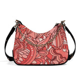 Stylish coral pink designer handbag with intricate floral patterns and elegant gold chain accent 