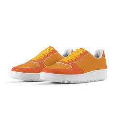 A pair of two-tone orange faux leather women's low top sneakers from the Core Series Essentials collection, featuring vibrant tangerine and giant orange color blocking with white soles and yellow laces. 