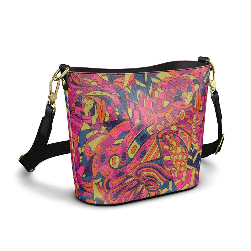 Large handmade bucket tote bag featuring the vibrant "Lina" pattern in pink, yellow, orange, and blue. The bag has a black adjustable shoulder strap and is available in either bubble or smooth leather finishes Blissfully Brand Made in England