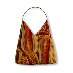 Vibrant Ame print canvas tulip bag with African-inspired tribal patterns in orange, yellow, and brown tones, featuring a single strap and unique abstract design - Profonde by Blissfully Brand