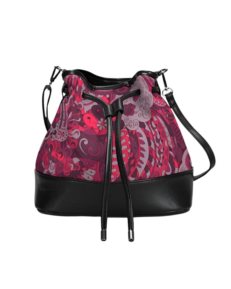 Stylish bucket bag with vibrant pink and red paisley pattern, black leather trim, drawstring closure, and adjustable shoulder strap. Designer handbag featuring unique floral print, spacious interior, and versatile crossbody design for fashionable everyday use