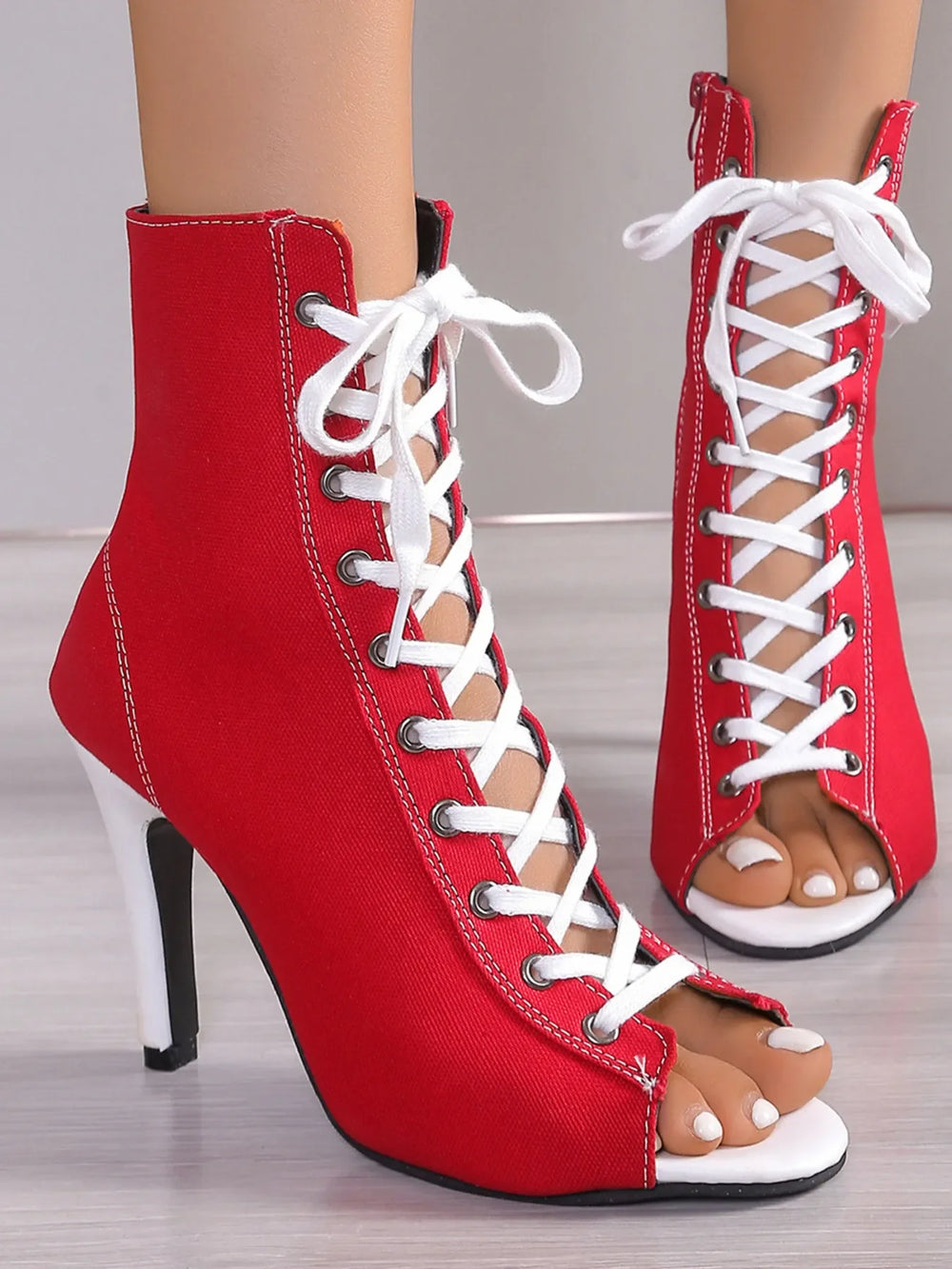 Vibrant red canvas open-toe ankle boots with white sneaker-style lacing, a slender stiletto heel, and white sole accents, embodying a bold retro-funk statement - Bliss & Tell by Blissfully Brand