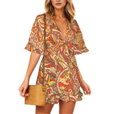 Vibrant Miarna print romper with front tie knot, flowy sleeves, and ruffled hem, Psychedelic Retro Floral Autumn Colors Blissfully Brand