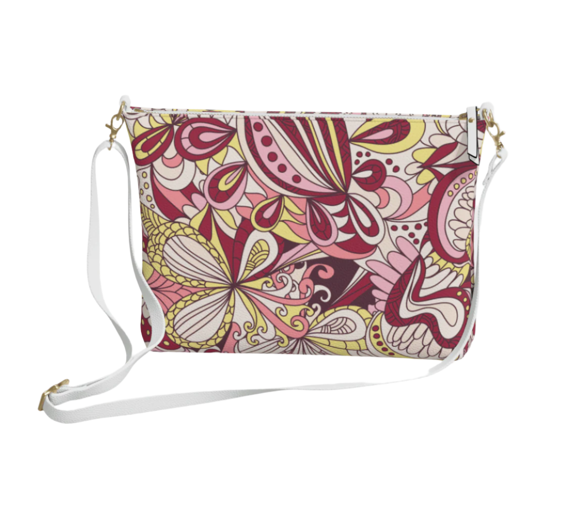 Stylish vegan leather crossbody bag featuring a vibrant Piki print in shades of red, pink, and yellow. Adjustable strap, zipper closure. Psychedelic floral - Blissfully Brand